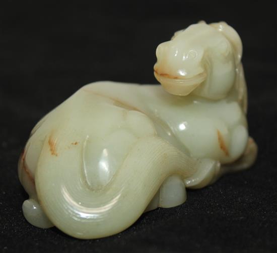 A Chinese celadon and brown jade figure of a recumbent horse, 20th century, 9.5cm
